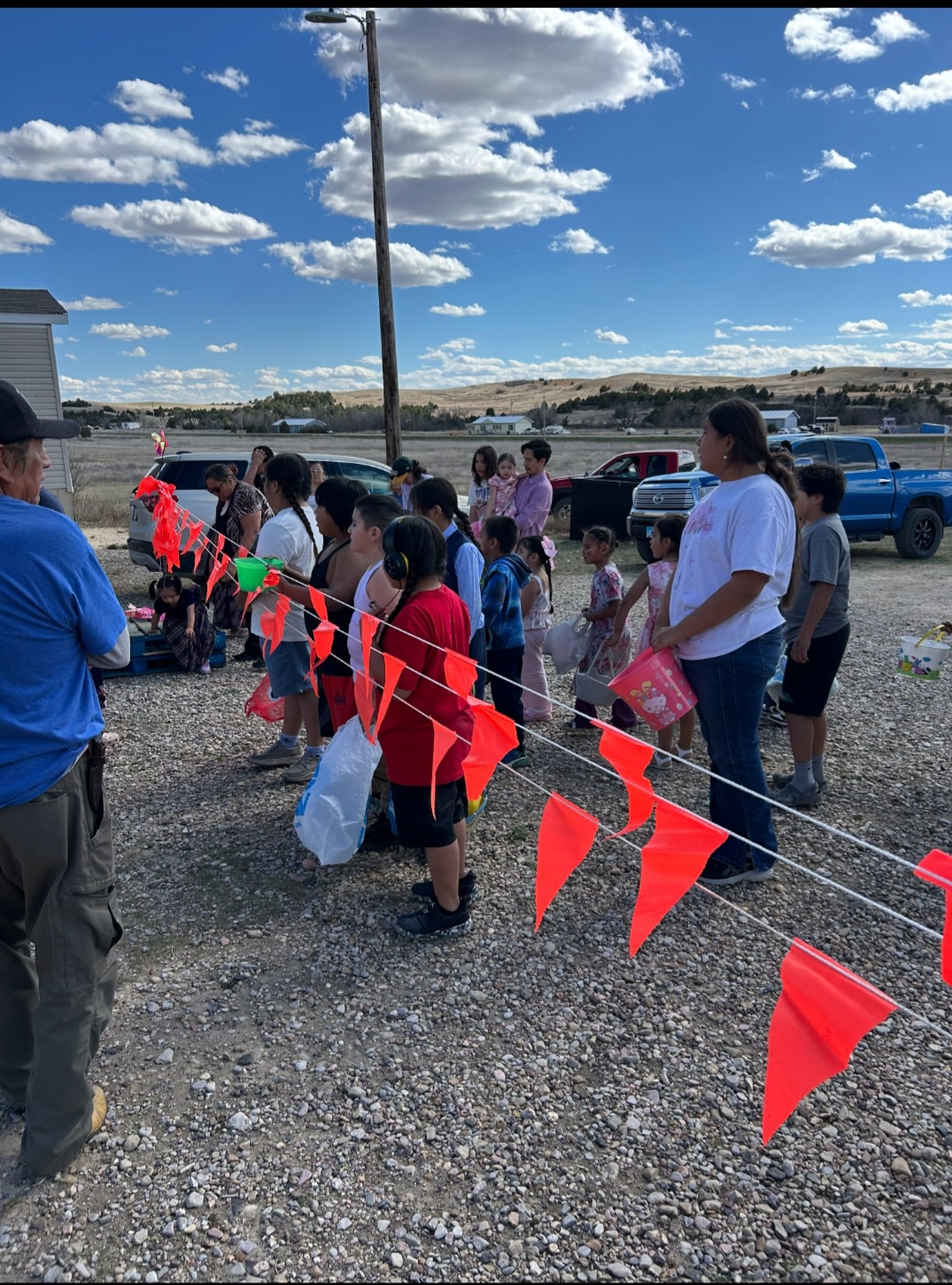 Native families, youth, and community members gathered together outdoors